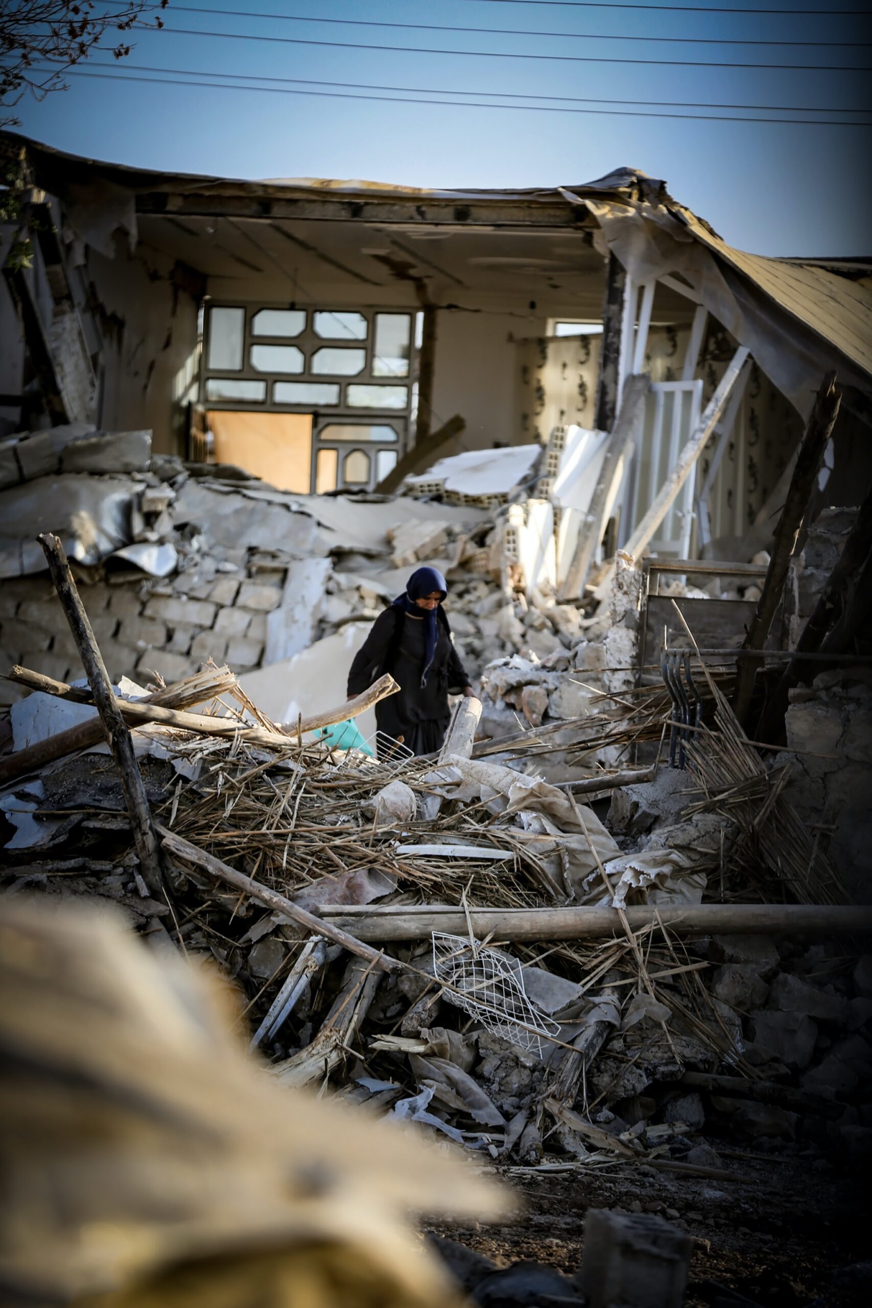 Eine Person steht in einem Erdbeben-zerstörtem Haus.